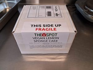 A postal box containing a vegan lemon cake